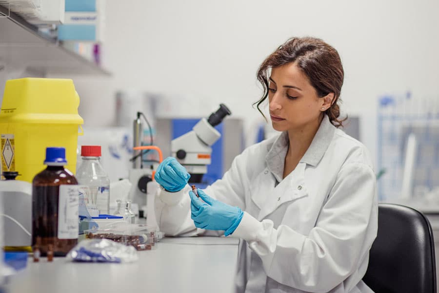 Lab technician in gloves processing a urine sample for UTI testing Lab technician in gloves processing a urine sample for UTI testing